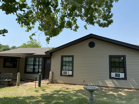 Finished tan vinyl siding with contrasting dark trim on the front of a home.