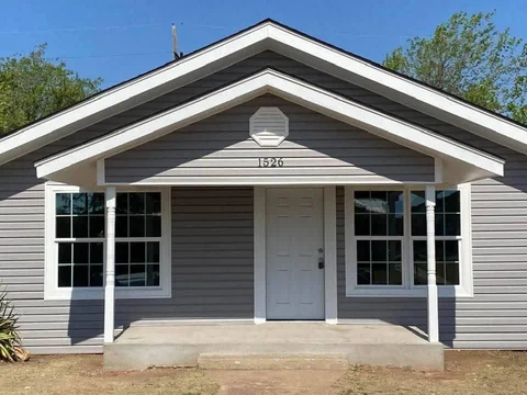 Finished gray exterior and white porch trim on a single-story home.