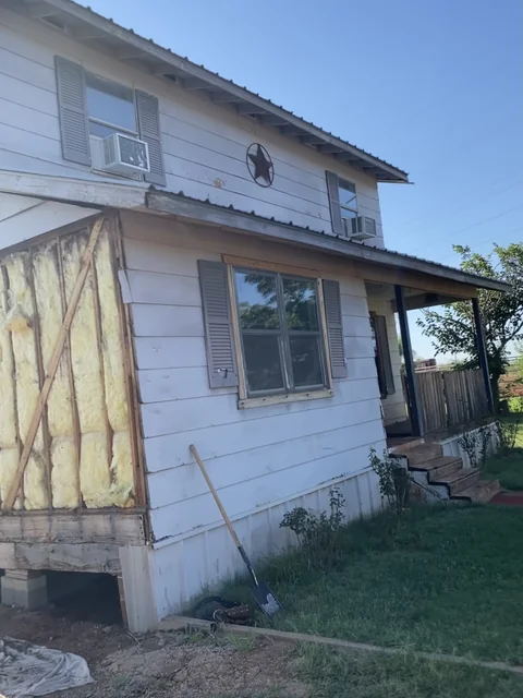 Closer view of the same home’s existing siding, windows and exposed sheathing.
