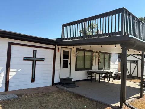 White siding and dark trim around the patio and raised deck at Bruce’s home.