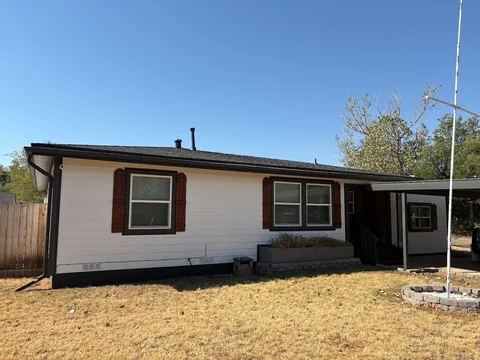 White siding, darker trim and shutters on the front of Bruce’s own home.